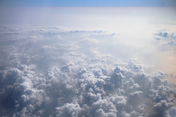 Airplane window overlooking the beautiful clouds and the earth. Sunset in flight on vacation. Tourist theme. Stock photo