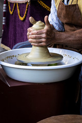 hands of a potter creating a piece of clay