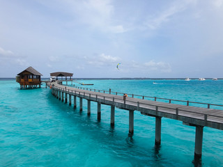 モルディブのコバルトブルーの海に続く木の橋