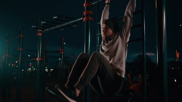 Guy doing abs workout outdoor at nighttime.