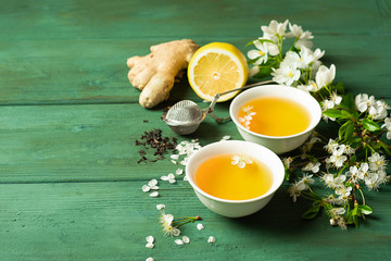 Tea lemon ginger with honey in a white cup on a wooden rustic background. Healthy drink for detox health.