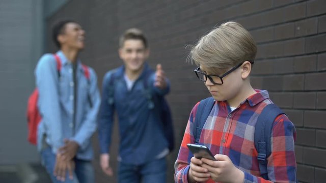 Teens mocking boy with phone, recognized him from shameful video, cyberbullying