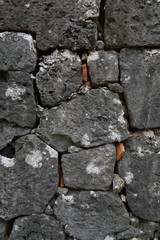 沖縄の古い石垣の隙間に赤瓦のかけら
