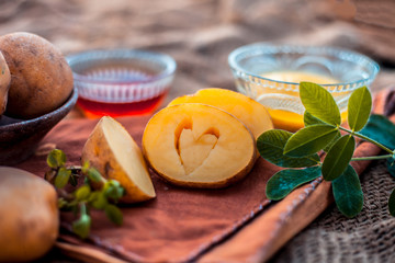 Potato juice's face pack or face mask in a glass bowl on jute bag's surface consisting of potato juice and honey.Used for skin whitening purpose along with entire ingredients.Horizontal low angle.