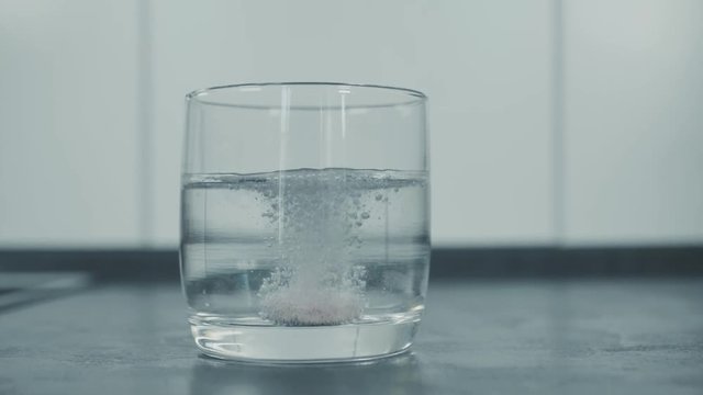 slide to a glass with water effervescent headache tablet dissolve slow motion