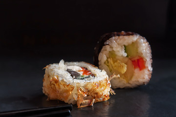 one serving close up traditional Japanese cuisine roll with onion chips outside on black background - Image