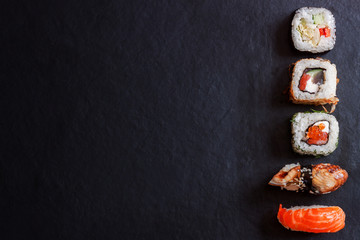 Top view traditional japanese sashimi sushi on black board background copy space