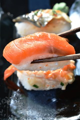 salmon Sushi Japanese food picking in wooden chopsticks 