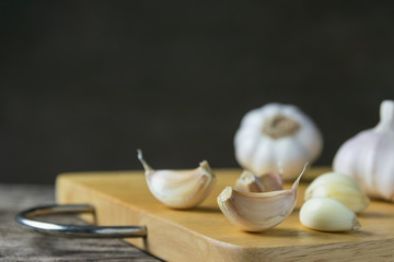 Closeup garlic on wooden texture on for cooking on dark background