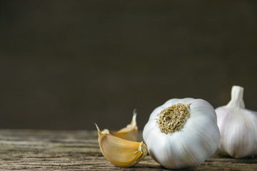 Closeup garlic on wooden texture on for cooking on dark background
