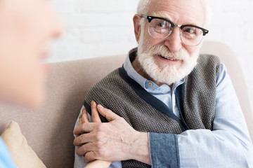 Selective focus of glad elderly man looking at nurse