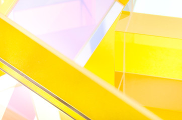 Bright glass figures on a yellow background close-up, abstraction