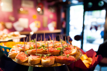 close up of italian style happy hour with italian food and tapas above table indoors of bar for young people