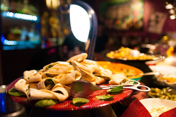 close up of italian style aperitivo food, small piadine with celebrate the happy hour inside bar on top in the evening