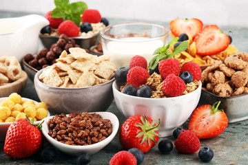 Cereal. Bowls of various cereals, berries and milk for breakfast. Muesli with kids cereals.