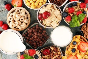 Cereal. Bowls of various cereals, berries and milk for breakfast. Muesli with kids cereals.