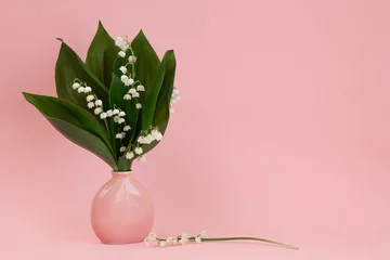 Fotobehang Boeket van lelietje-van-dalen in een roze vaas op een roze achtergrond © Вера Шилина