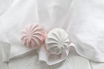 Fototapeta na wymiar White-pink homemade marshmallows on a white table. Top view. 