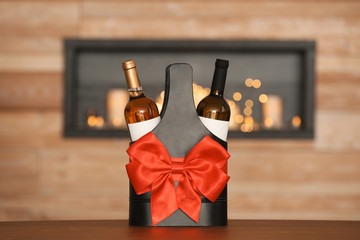Festive package with bottles of wine on table in room