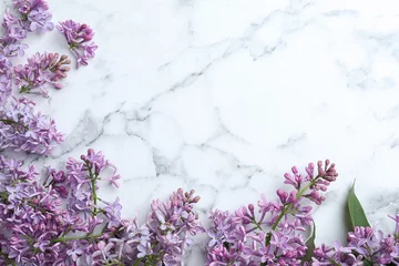Fotobehang Blossoming lilac flowers on marble table, flat lay. Space for text © New Africa