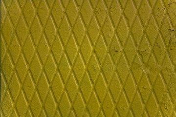 Fototapeta premium yellow shabby old concrete wall with a diamond pattern and peeling paint. rough surface texture