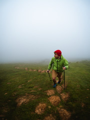 Young man with headlamp hiking through the fog