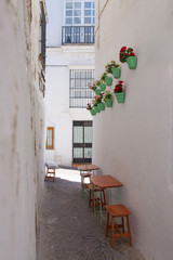 Fototapeta na wymiar White village Arcos de la Frontera, Cadiz, Andalusia, Spain. Little restaurant terrace at narrow street