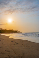 beautiful tropical caribbean beach with blue ocean at sunset