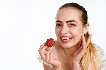 girl eagerly eating strawberries on white background.