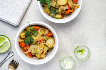Vegetable stew of carrots, potatoes, cabbage and zucchini with greens
