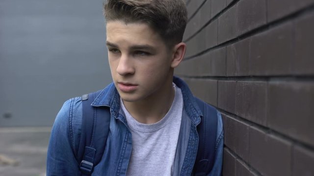 Depressed lonely victim of bullying getting head punch from cruel classmate