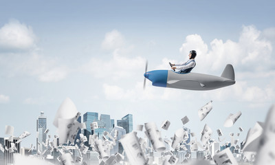 Businessman driving propeller plane above downtown © adam121