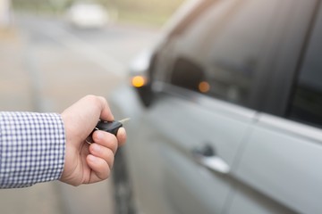 Men pressing hands on the remote control car alarm system Car theft alarm concept