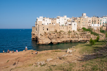 Fototapeta na wymiar Panoramic city skyline with white houses of Polignano a Mare, town on the rocks, Puglia region, Italy, Europe. Traveling concept background with blue Mediterranean sea with tourists and nature