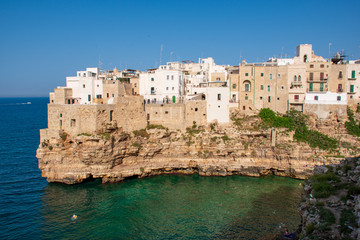 Fototapeta na wymiar Panoramic city skyline with white houses of Polignano a Mare, town on the rocks, Puglia region, Italy, Europe. Traveling concept background with blue Mediterranean sea