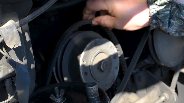 TThe mechanic changes the timing belt on the bus engine. Check the timing belt . Replacing the timing belt on the engine in daylight 