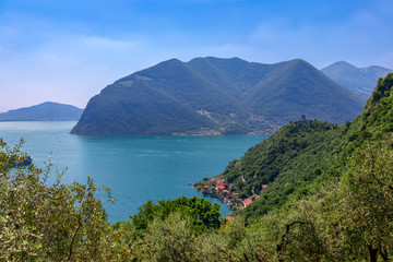 Beautiful view of Lake Iseo with a small old town on the shore and a medieval castle on the hill.