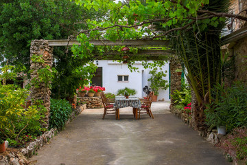 Tisch und Stühle in einem mediterranen Garten