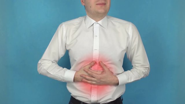 Man has pain in stomach or abdomen area due to Heartburn or Gastritis. Pancreatitis. Concept of pyrosis or cardialgia. Manager in white shirt suffers from Peptic ulcer disease or acid indigestion
