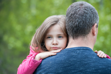 Portrait of one sad daughter hugging her father