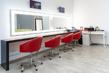 Bright dressing room with red chairs. a simple room for make-up several comfortable chairs are in a row.