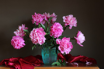 lush bouquet of pink peonies in a blue glass vase