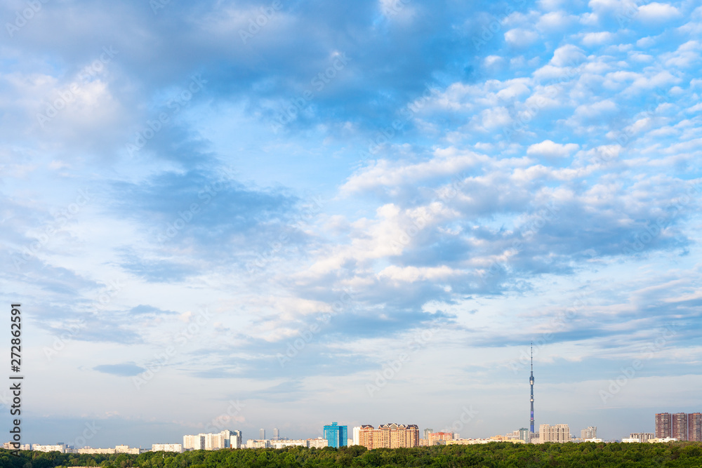 Wall mural summer afternoon sky with clouds over city