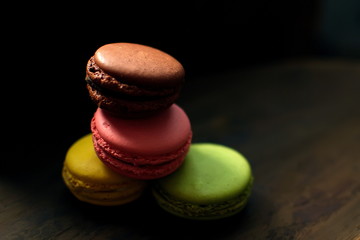 Multi-colored macaroons on a wooden tray. Pink, yellow and green macaroon. - 272862572