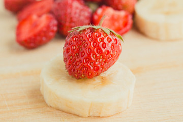  fresh strawberries and banana on wooden background