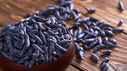 oblong fruit of the honeysuckle berries on wooden background.