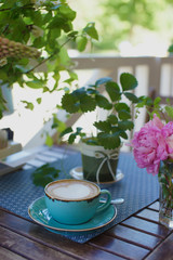 A cup of coffee and flowers on the table