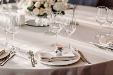Fototapeta na wymiar Wedding in the style vintage. Decoration of the table with flowers and cutlery. Composition from flowers. Elegant dining table in peach-purple color. Indoors wedding reception venue with festive decor