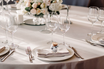 Wedding in the style vintage. Decoration of the table with flowers and cutlery. Composition from flowers. Elegant dining table in peach-purple color. Indoors wedding reception venue with festive decor