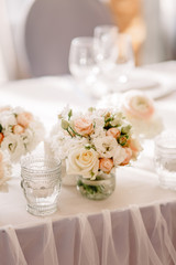 Obraz na płótnie Canvas Wedding in the style vintage. Decoration of the table with flowers and cutlery. Composition from flowers. Elegant dining table in peach-purple color. Indoors wedding reception venue with festive decor